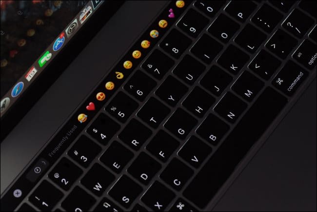 A backlit MacBook Pro keyboard with a touch bar.